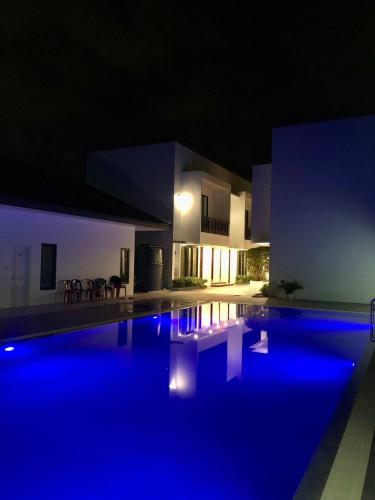 a house with a swimming pool at night at Silom Residence Khlonghae Hotel in Hat Yai