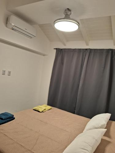 a bedroom with a bed with a gray curtain at Casa en Venado Tuerto in Venado Tuerto