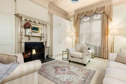 a living room with two chairs and a fireplace at Washington Cottage in Angaston