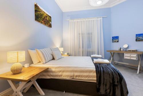 Washington Cottage في Angaston: غرفة نوم بسرير وطاولة خشبية