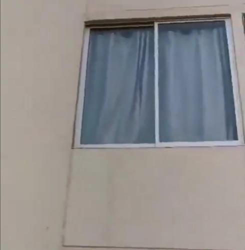 a window with blue curtains on a white wall at Apto San Francisco de Asis in Valledupar