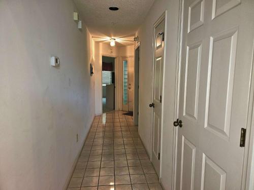 a hallway with a tile floor and a white door at Tidewater- Teal lake #2521 in North Myrtle Beach