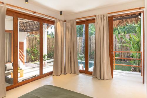 an open living room with sliding glass doors at SEACLUB Siargao in General Luna
