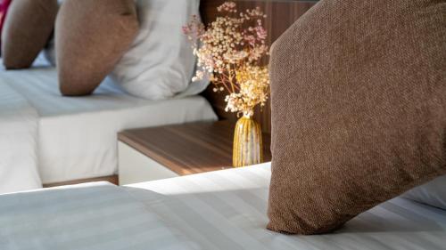 a group of beds with a vase of flowers on them at House of Pi Pleiku in Pleiku