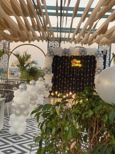 Una habitación con globos blancos y un escenario con un cartel. en Hotel Saif Ranthambhore, en Sawāi Mādhopur