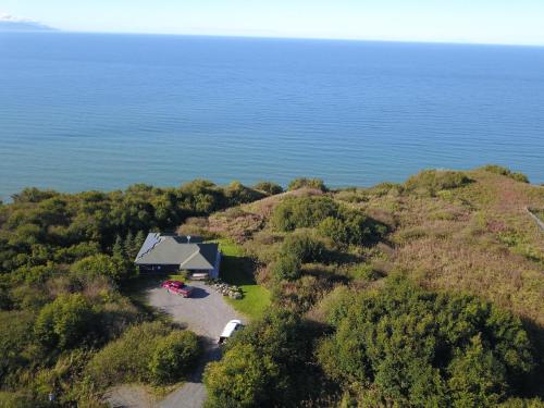 an aerial view of a house on a hill next to the water at Raven Guesthouse in Homer