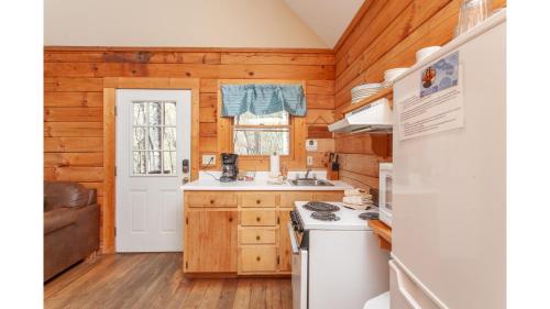 a kitchen with wooden walls and a white stove top oven at Solitude in Bryson City
