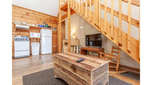 a kitchen and living room with a table and a staircase at Solitude in Bryson City