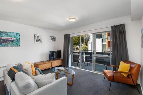 a living room with a couch and a tv at Handy CBD Covered Free Parking Gym 2 Bdrm in Christchurch