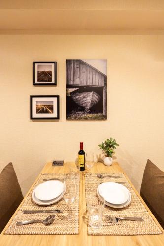 a table with two plates and a bottle of wine at Ostay Ikebukuro Dairaku Hotel Apartment in Tokyo
