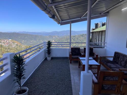 a balcony with a table and chairs and a view at Alpine Homestay in Kohīma