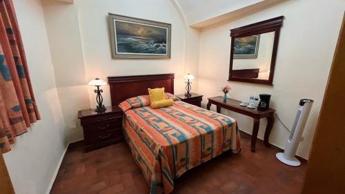 a hotel room with a bed and a mirror at Hotel Antigua Casa de Piedra in San Miguel de Allende