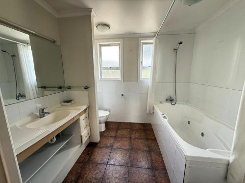 a bathroom with a tub and a sink and a toilet at Lavana Motel in Hastings