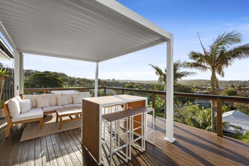 a white canopy on a deck with a couch and a table at Chic Coastal 1-Bedroom Home with Balcony & BBQ in Deewhy