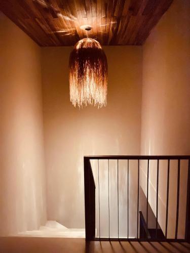 a chandelier hanging from a ceiling with a staircase at Impresionantes vistas al Volcán Arenal, cine privado y ubicación ideal in Palma
