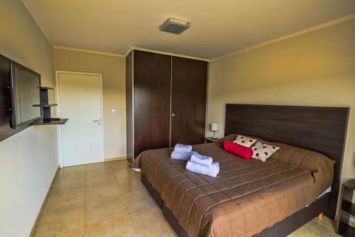 a bedroom with a bed with two pillows on it at Blackstone Country Villages Hotel in Villa General Belgrano