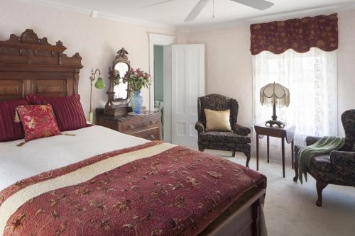a bedroom with a large bed and two chairs at Isaiah Jones Homestead Bed and Breakfast in Sandwich