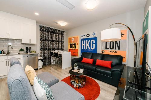 a living room with a couch and a kitchen at Modern suite near Airport Hospital Henday Town Ctr in Nisku