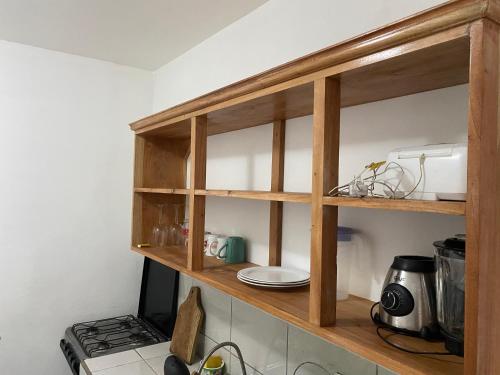 a kitchen with a wooden shelf above a stove at Apartamento KERU in San Juan del Sur