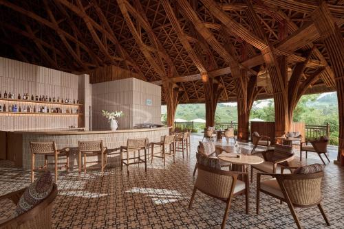 a restaurant with tables and chairs and a bar at Garrya Mù Cang Chải in Mù Cang Chải