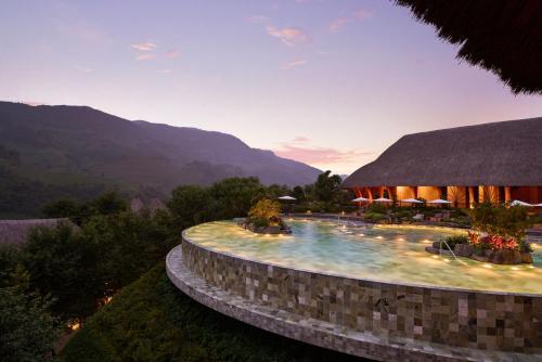 a resort with a swimming pool with mountains in the background at Garrya Mù Cang Chải in Mù Cang Chải