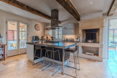 - une cuisine avec une grande île au milieu d'une pièce dans l'établissement Mas de Cassiathea - Exceptional Property in Provence, à Bonnieux