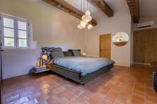 une chambre avec un grand lit dans une pièce dans l'établissement Mas de Cassiathea - Exceptional Property in Provence, à Bonnieux