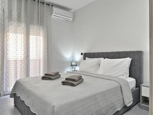 KiladaにあるKilada Luxury Apartment 1の白いベッドルーム(ベッド1台、タオル2枚付)