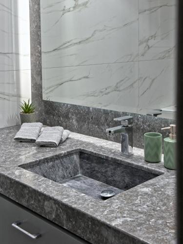 a bathroom with a marble sink and a mirror at Kilada Luxury Apartment 1 in Kilada