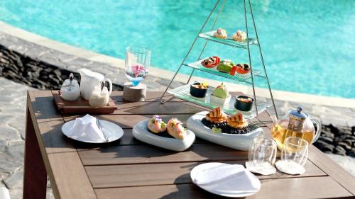 a table with plates of food on it next to a pool at Garrya Mù Cang Chải in Mù Cang Chải