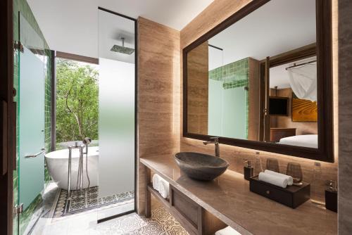 a bathroom with a sink and a tub and a mirror at Garrya Mù Cang Chải in Mù Cang Chải