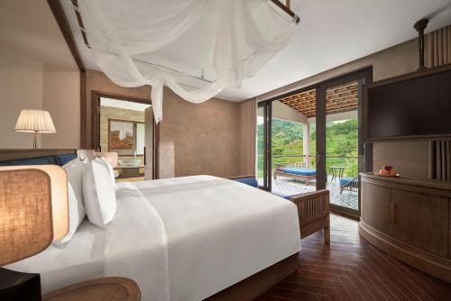 a bedroom with a large white bed and a balcony at Garrya Mù Cang Chải in Mù Cang Chải