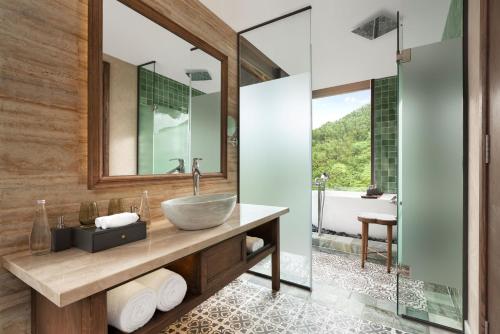 a bathroom with a vessel sink and a shower at Garrya Mù Cang Chải in Mù Cang Chải