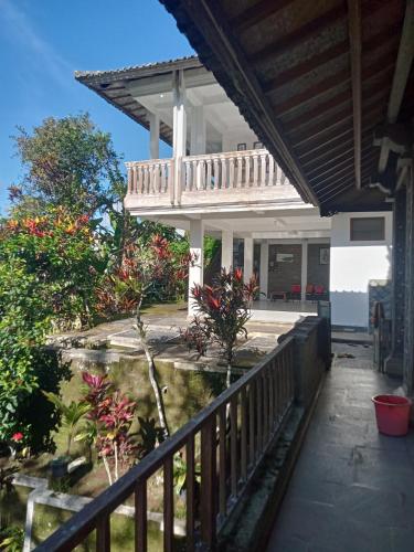 a porch of a house with a balcony at pranamastra bali in Jatiluwih