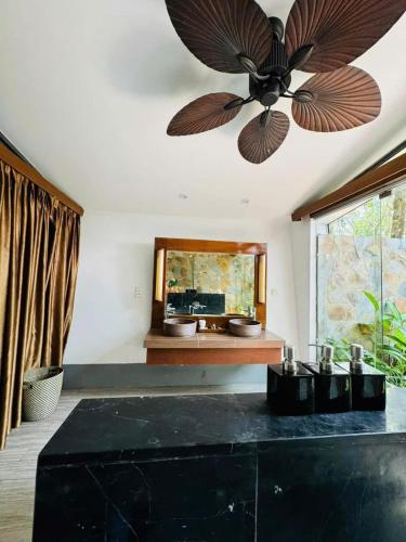 a ceiling fan in a room with a mirror at Biệt Thự chủ nhà tự doanh tại FLAMINGOS ĐẠI LẢI RESORT in Phúc Yên