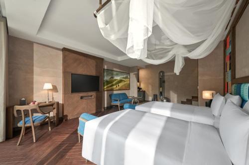 a hotel room with a bed and a tv at Garrya Mù Cang Chải in Mù Cang Chải