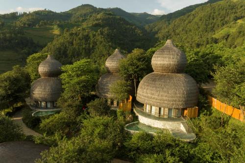 an aerial view of three domed buildings in the mountains at Garrya Mù Cang Chải in Mù Cang Chải