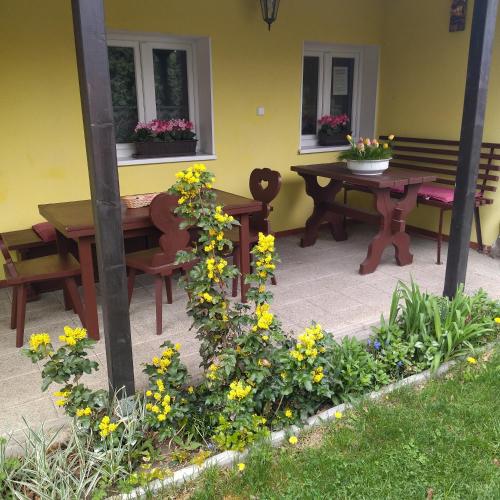 a patio with a table and benches and flowers at Všeborky in Dalovice