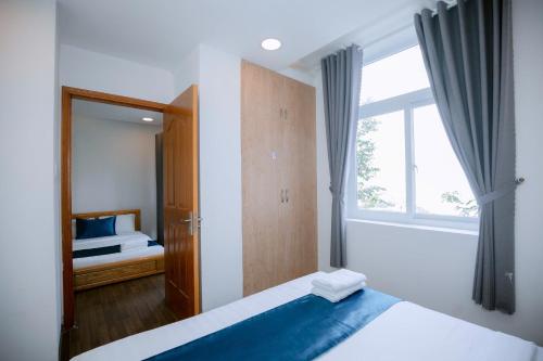 a small bedroom with a bed and a window at Blue Sea Luxury Hotel & Apartment Vũng Tàu in Vung Tau