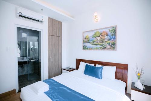 a bedroom with a large bed with a blue pillow at Blue Sea Luxury Hotel & Apartment Vũng Tàu in Vung Tau