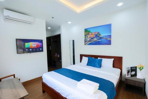 a bedroom with a large bed and a tv at Blue Sea Luxury Hotel & Apartment Vũng Tàu in Vung Tau
