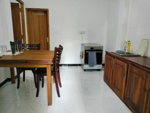 eine Küche mit Holztisch und Herd in der Unterkunft Laveranda Apartment ground floor and laverenda apartment upstairs in Nikawatawana