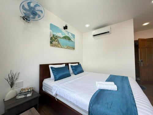 a bedroom with a large bed with blue pillows at Blue Sea Luxury Hotel & Apartment Vũng Tàu in Vung Tau