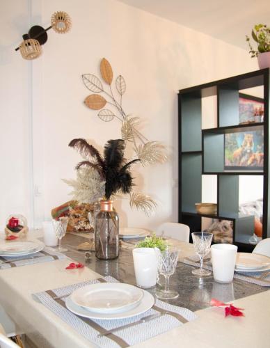 une table de salle à manger avec des assiettes et des verres dessus dans l'établissement Chambre dans T5 96m2 meublé tt équipé, à Lorient