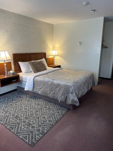 a bedroom with a large bed and a rug at Maple Creek Motor Inn in Maple Creek