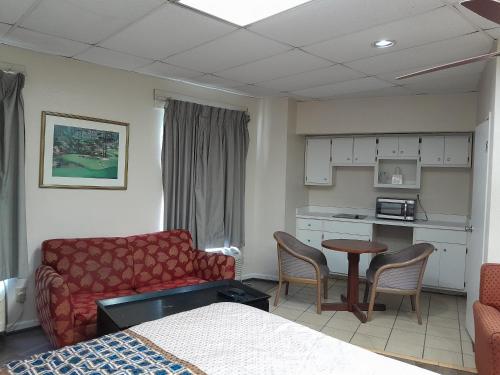 a room with a couch and a table and a kitchen at Budgetel Inn and Suites- FORT GORDON in Augusta