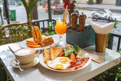 a breakfast plate of eggs and toast and a glass of orange juice at La Bonita - Phu My Hung in Ho Chi Minh City