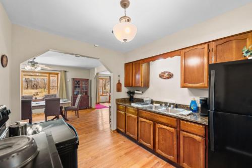 a kitchen with wooden cabinets and a black refrigerator at The Young’s - Northern Indiana in Gary