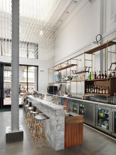 a restaurant with a counter with stools and a bar at Axiom Hotel in San Francisco