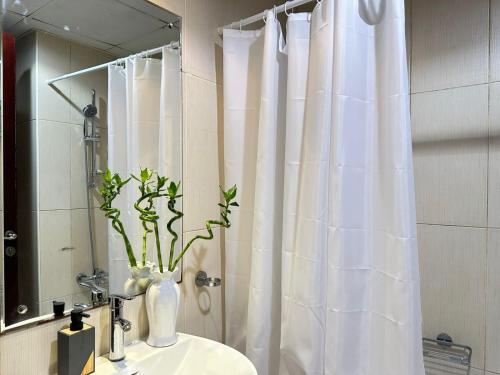 a bathroom with a white shower curtain and a sink at Sweet Home Lagoon View in Ras al Khaimah
